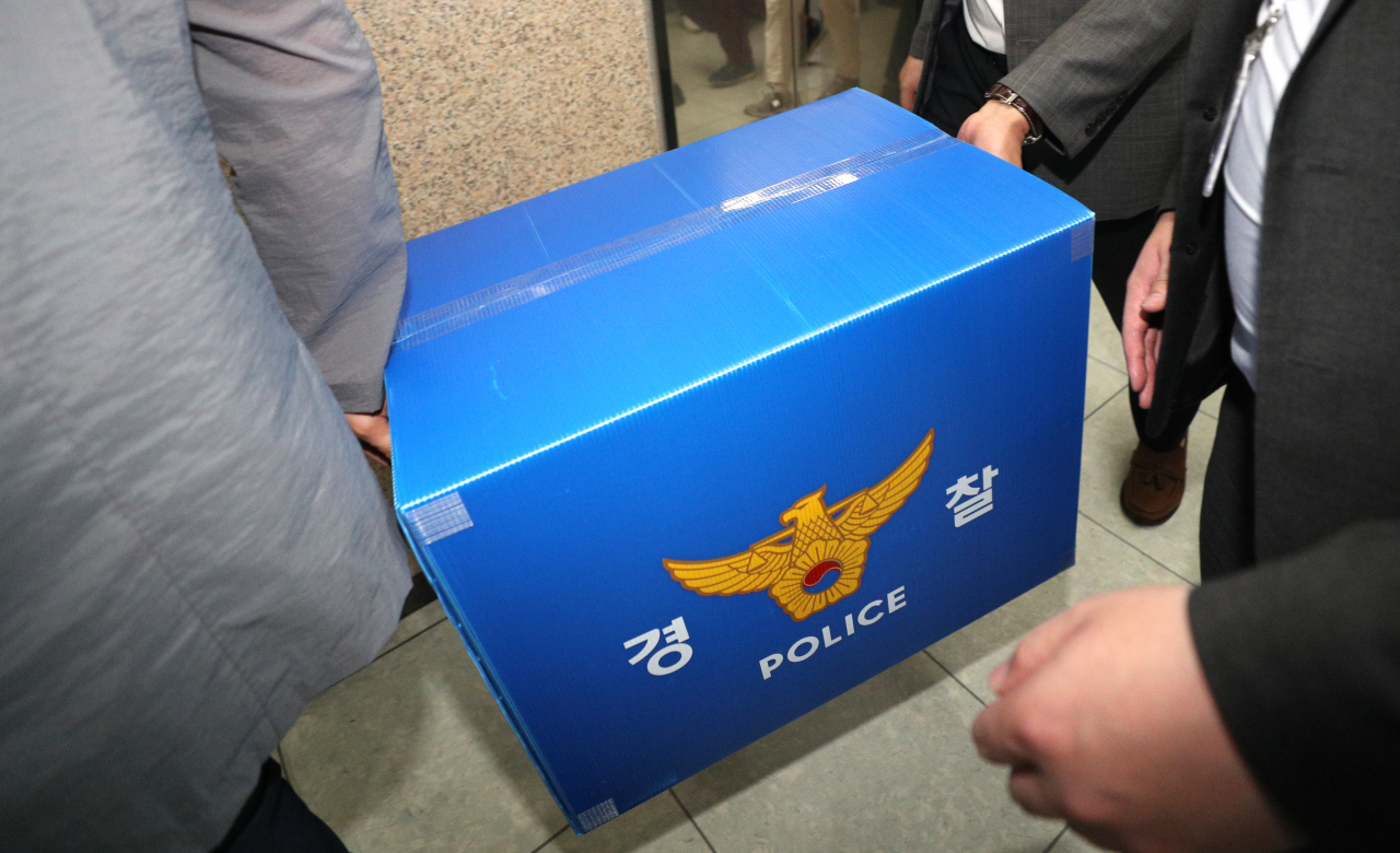 Investigators leave Daegu City Hall with documents after a seizure and search, Friday. (Yonhap)