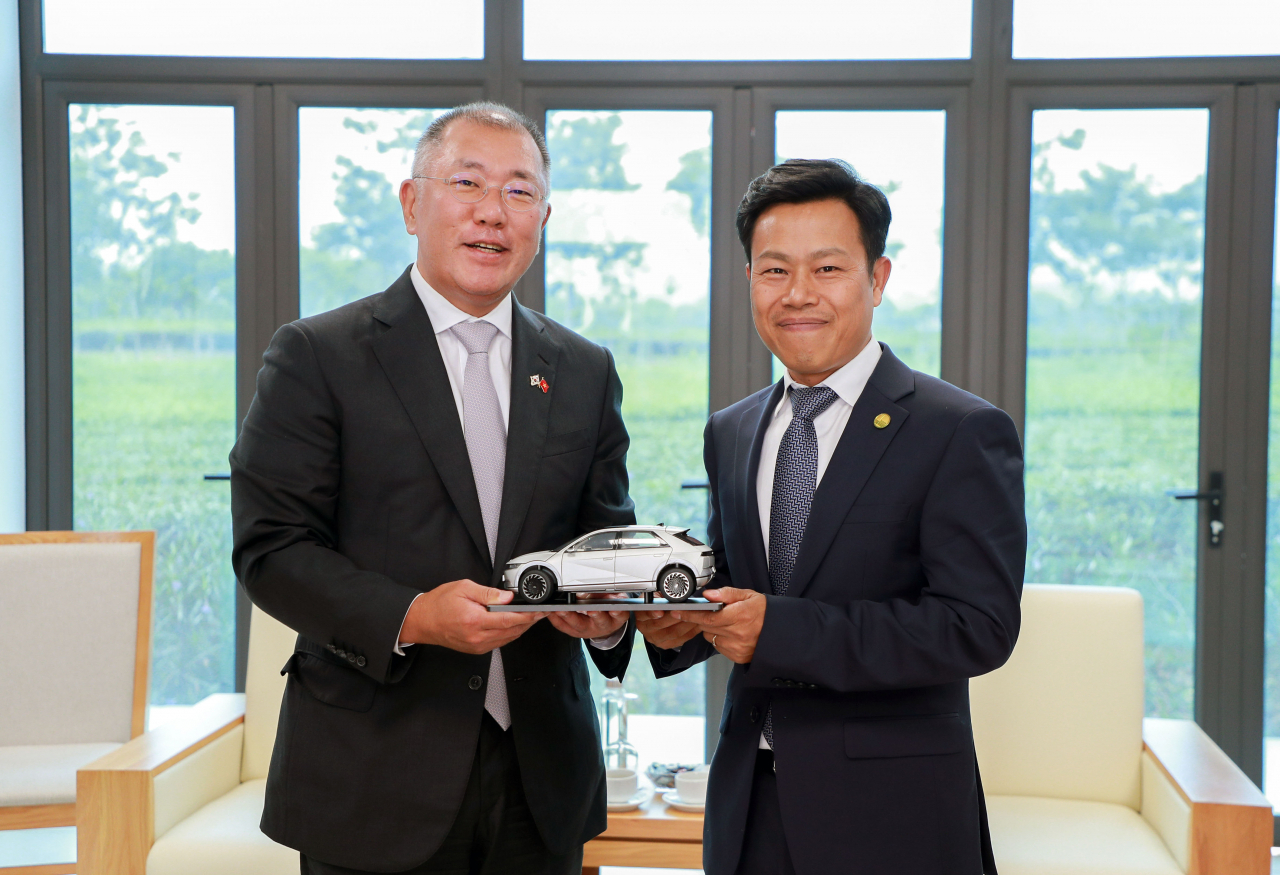 Hyundai Motor Group Executive Chair Chung Euisun (left) and Le Quan, President of Vietnam National University, Hanoi, pose for a photograph as they hold a figure of Hyundai Motor’s all-electric vehicle Ioniq 5 during their meeting at the school’s Hoa Lac campus on Friday. (Hyundai Motor Group)