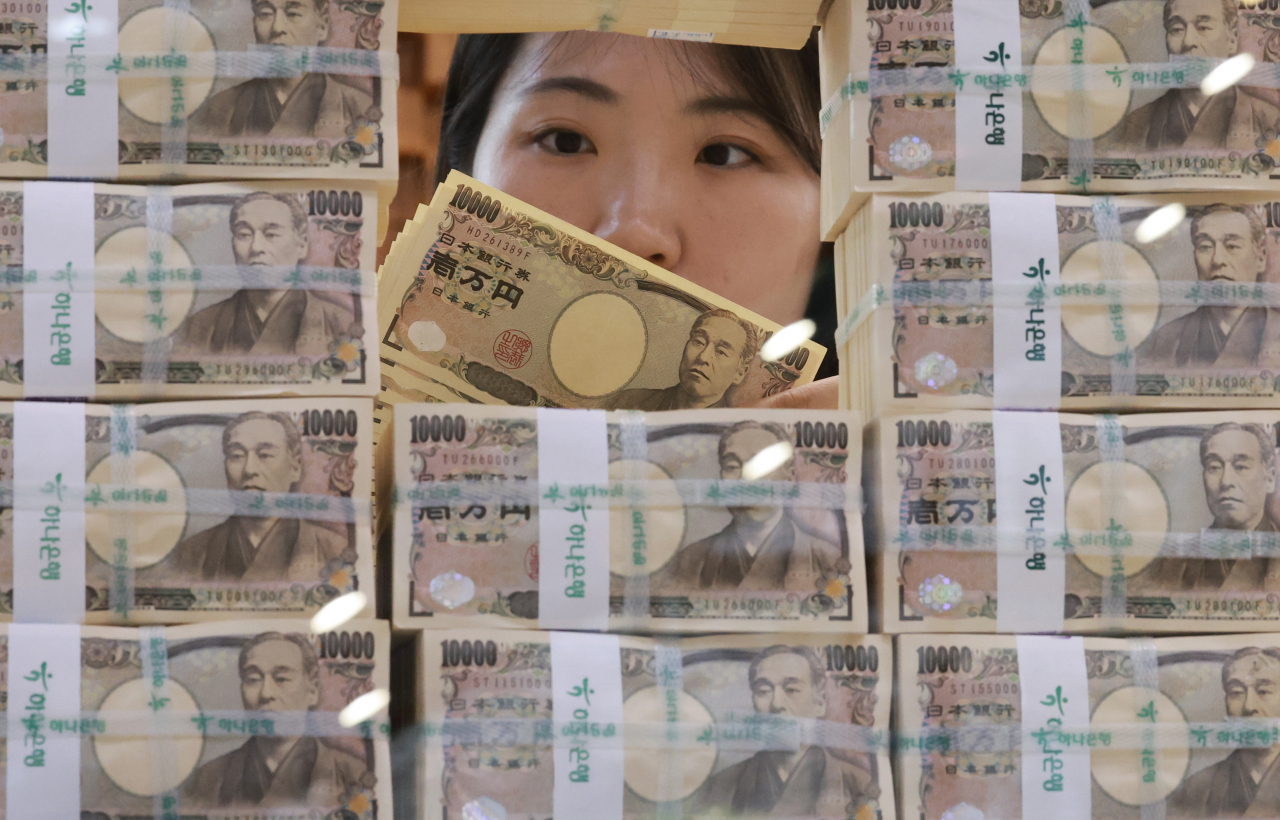 A clear examines Japan’s 10,000 yen banknotes at the headquarters of Hana Bank in central Seoul on June 19. (Yonhap)