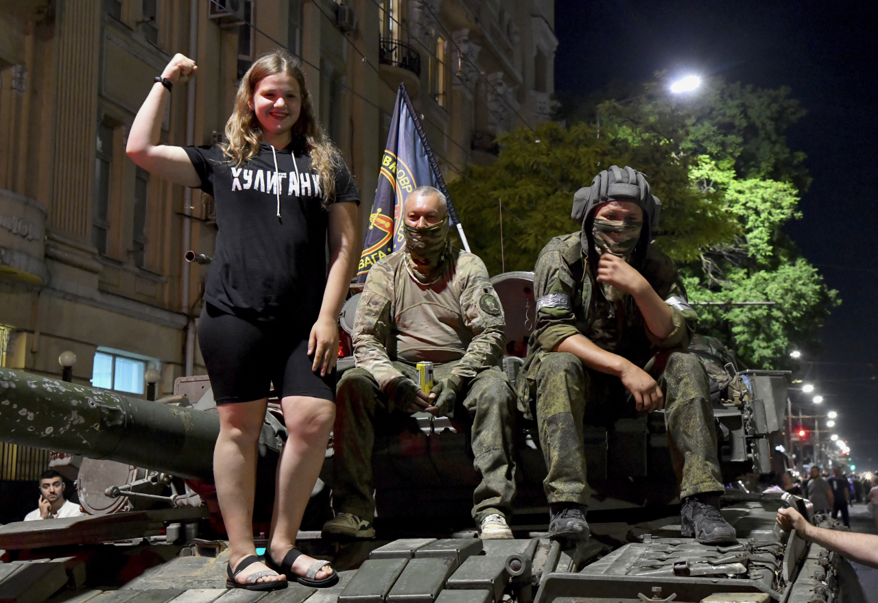 Members of Wagner Group pose with a local girl as they prepare to leave downtown Rostov-on-Don, southern Russia, Saturday. (AFP-Yonhap)