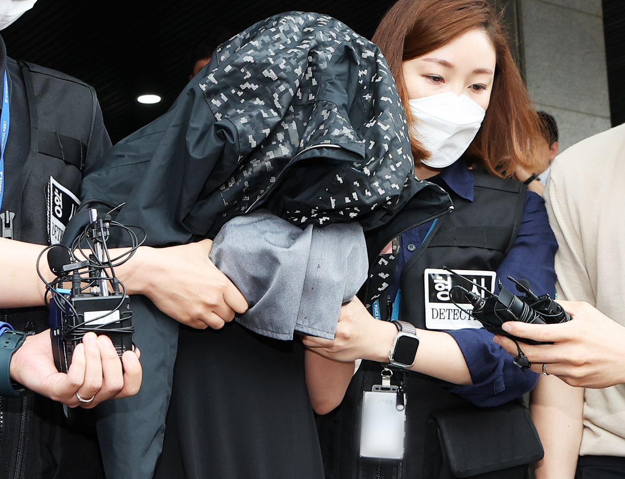 A suspect arrested for allegedly killing her two newborn babies and storing their bodies in a refrigerator is escorted to the Prosecutors' Office in Suwon, Gyeonggi Province, on June 30. (Yonhap)