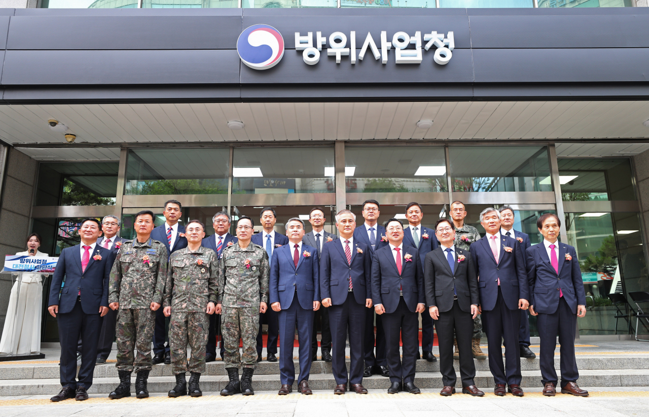 Government and military officials pose for a photo during a signboard hanging ceremony for the state-run Defense Acquisition Program Administration in Daejeon, 139 kilometers south of Seoul, on Monday. (Yonhap)