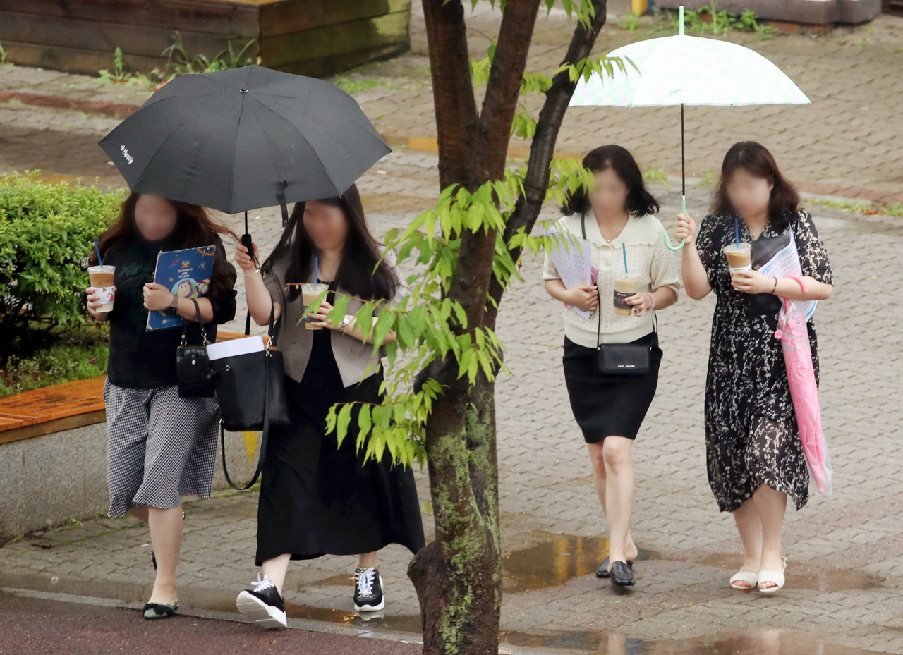 People walk with umbrellas at Seo-gu, Gwangju, Tuesday, as rain falls nationwide. (Yonhap)