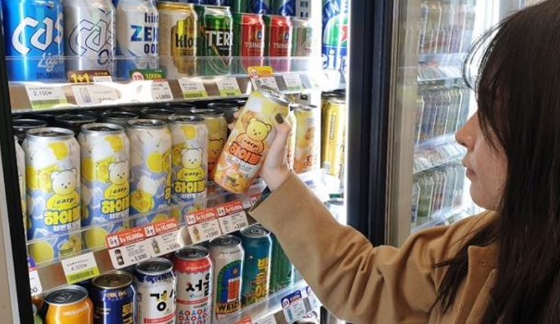 A woman holds a canned highball launched by CU in November last year. (BGF Retail)