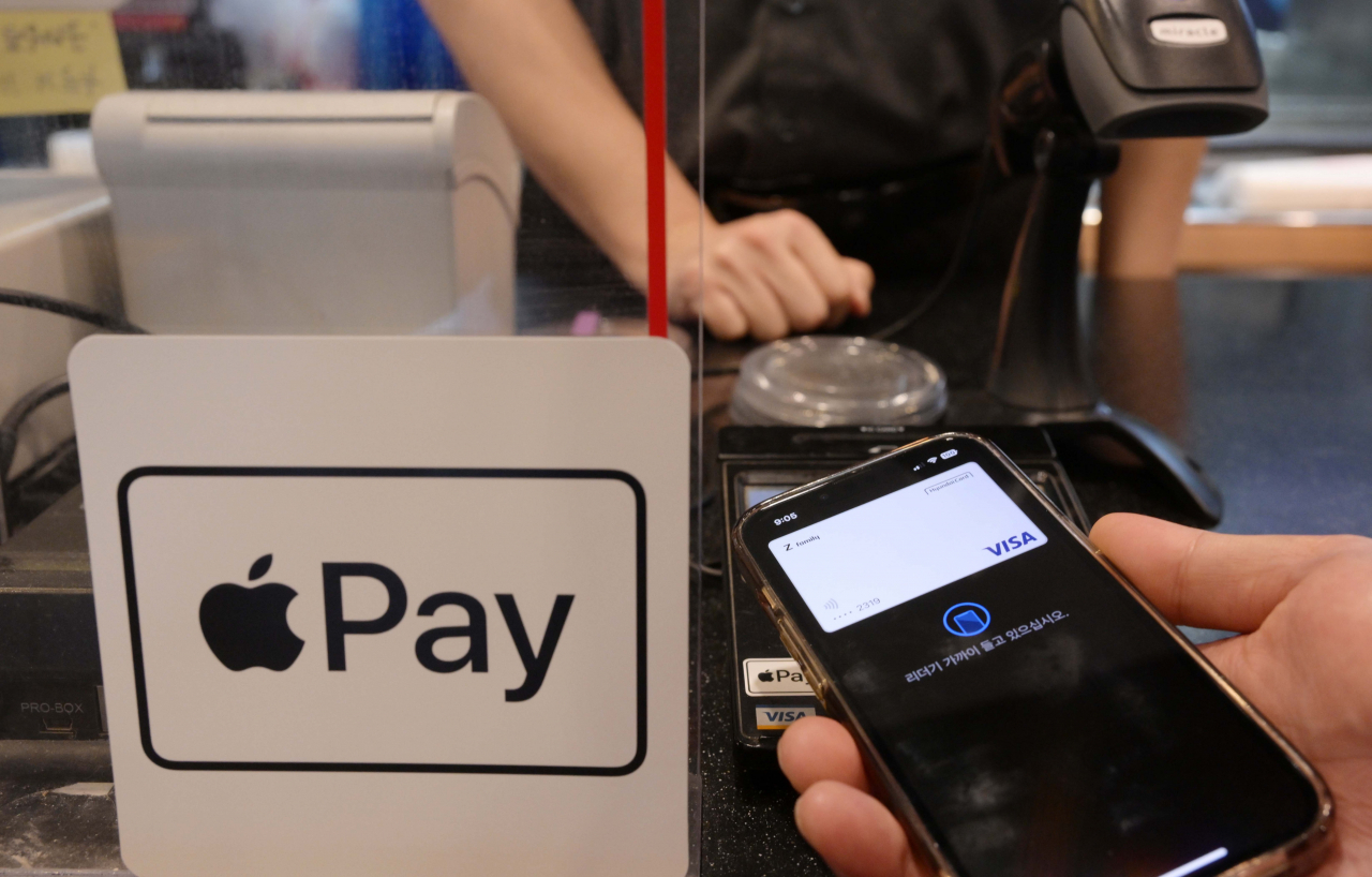 A customer uses Apple Pay to make a payment at a local fast food restaurant in Seoul. (Lee Sang-sub/The Korea Herald)