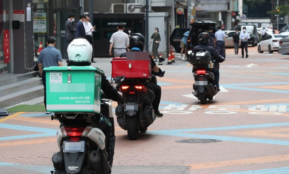 Delivery motorcycles drive down a street in Seoul. (Herald DB)