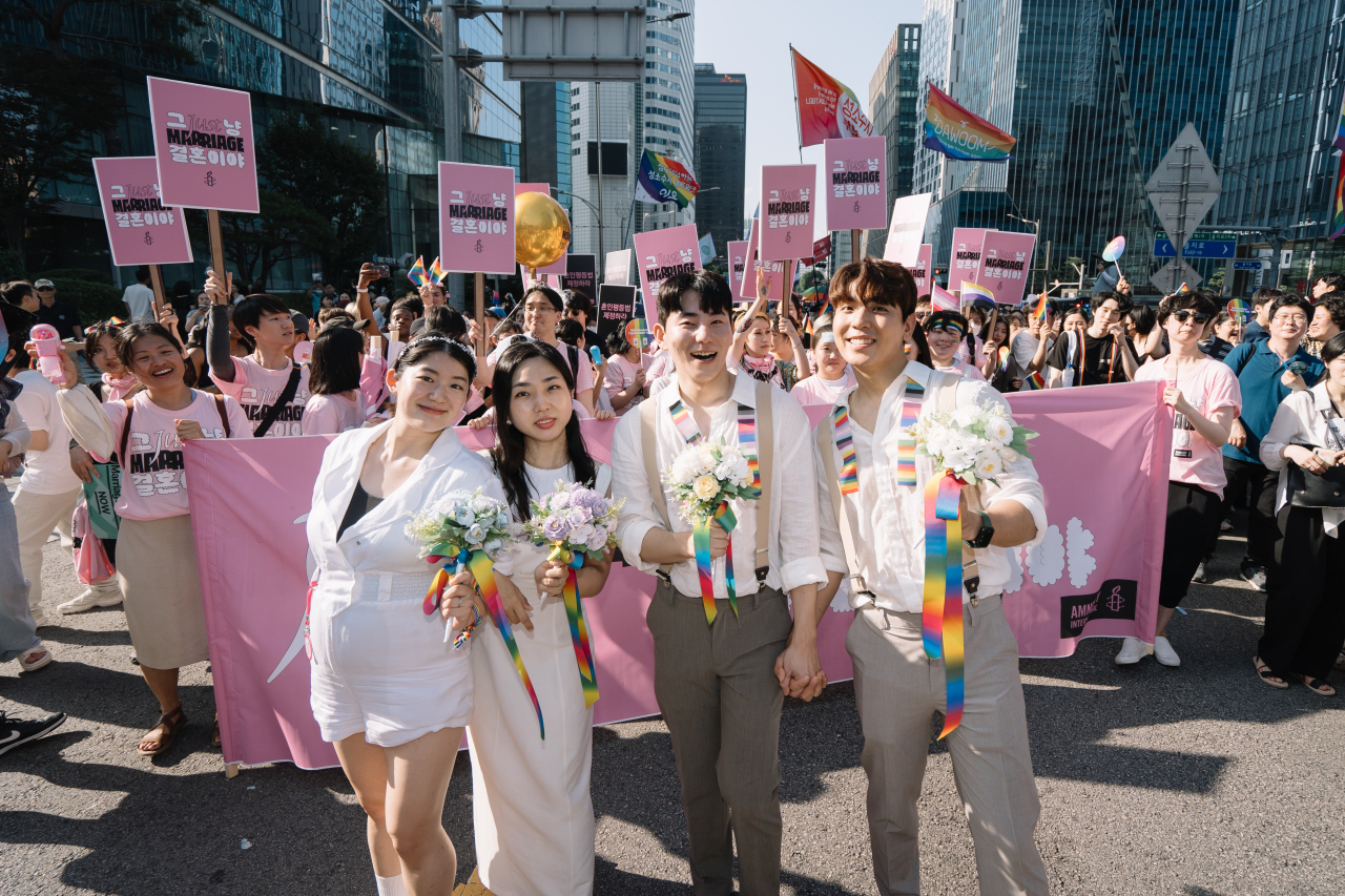 Kim Gyu-jin (far left), Kim Se-yeon (second from left) and other participants of the 2023 Seoul Queer Culture Festival held on July 1st in Seoul pose for a photo. (Yonhap)