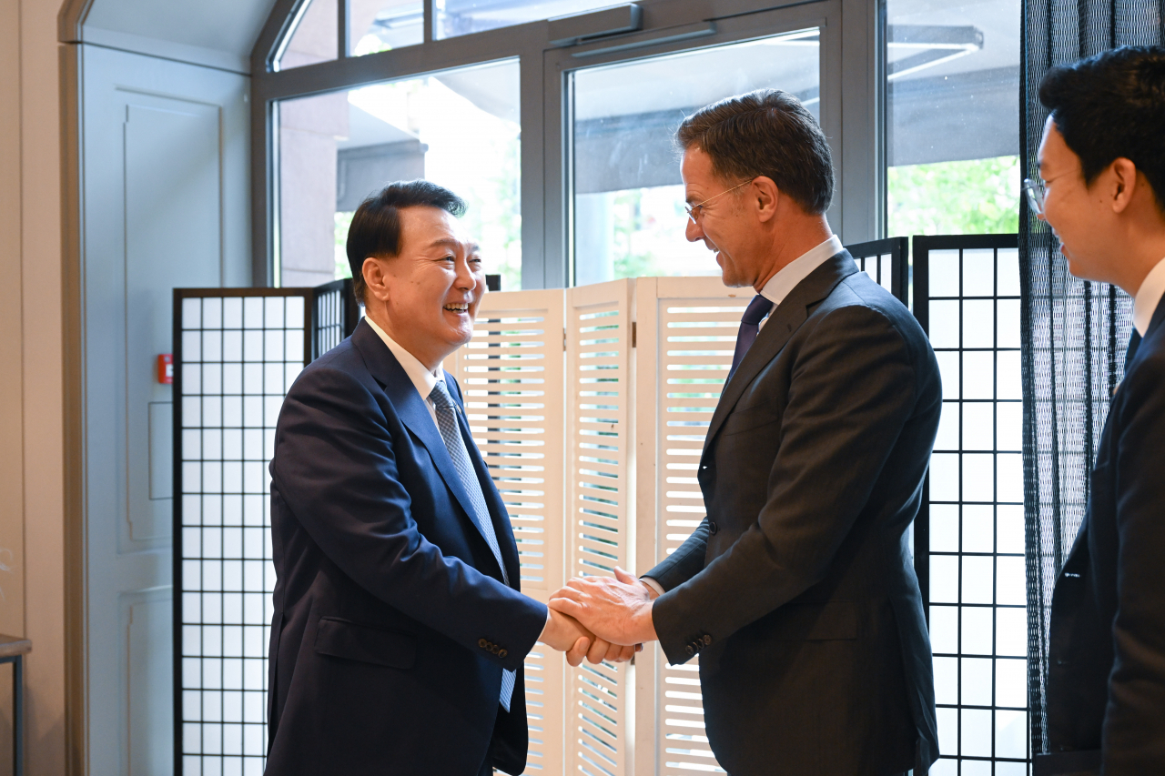 President Yoon Suk Yeol shakes hands with Dutch Prime Minister Mark Rutte at the summit held in Vilnius on Tuesday. (Yonhap)