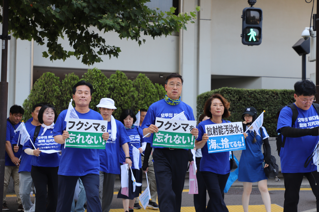 Democratic Party of Korea lawmakers march in the streets of Tokyo on Wednesday to protest Japan’s plan to discharge treated wastewater stored at tsunami-wrecked Fukushima nuclear power plant. (courtesy of Democratic Party of Korea)