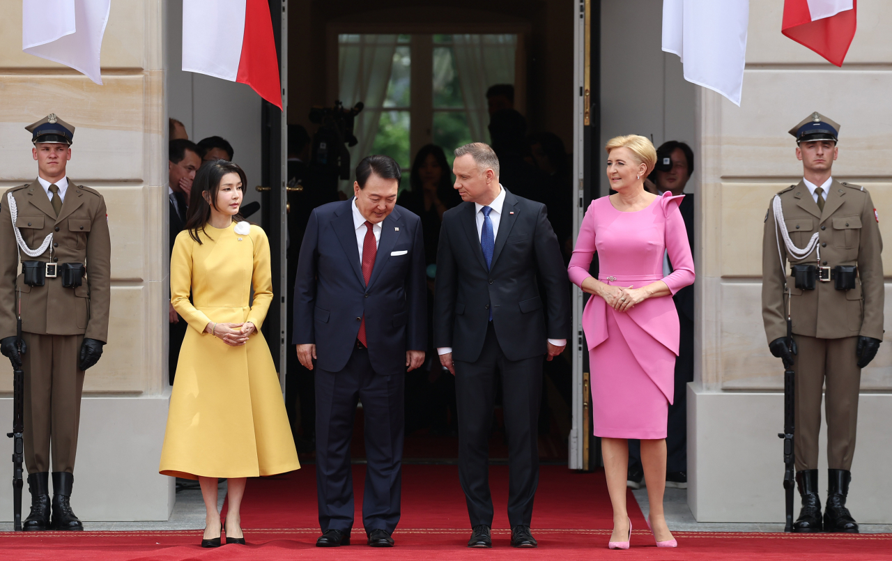 President Yoon Seok-yeol and First Lady Kim Kun-hee, who are on an official visit to Poland, talk with Polish President Andrzej Duda at the official welcome ceremony held at the Warsaw Presidential Palace on Thursday. (Yonhap)