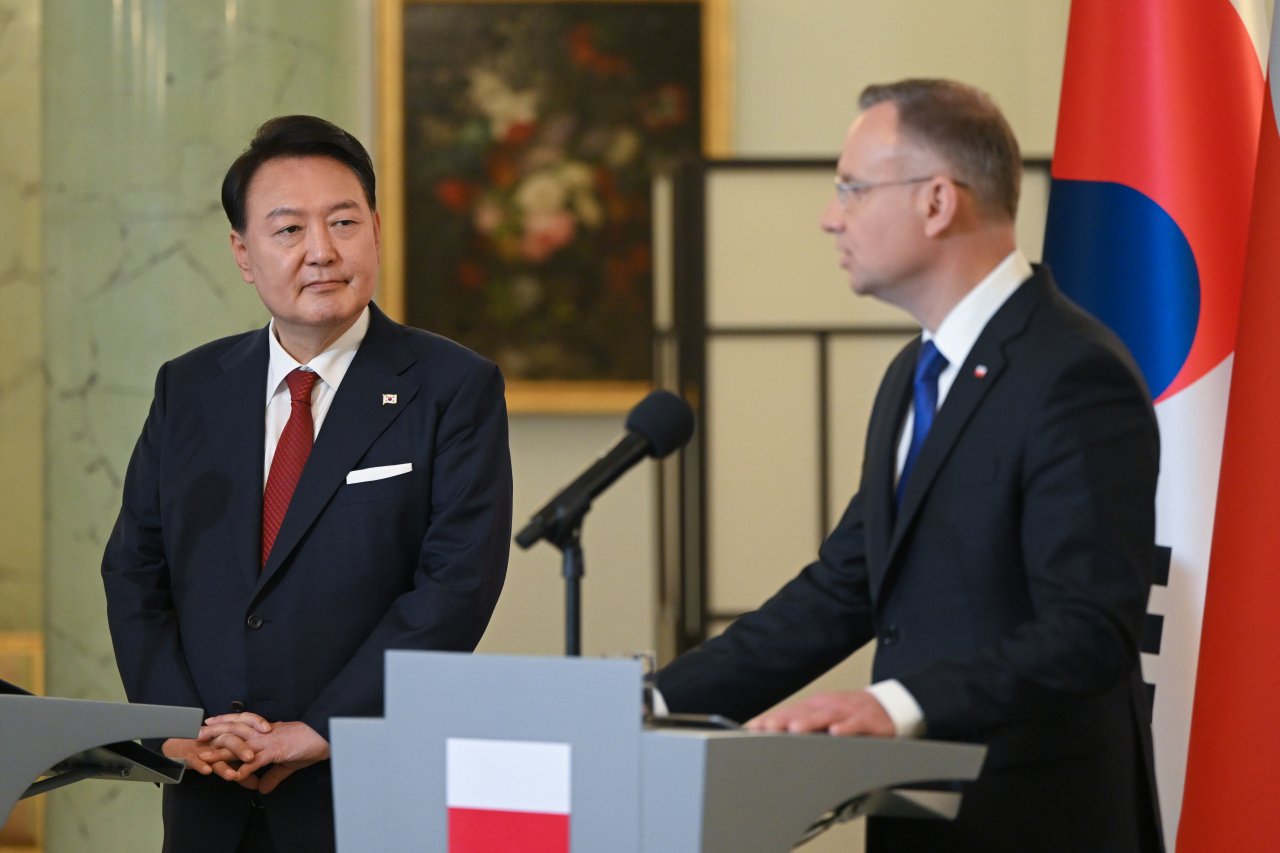 President Yoon Suk Yeol, who is on an official visit to Poland, listens to the remarks of Polish President Andrzej Duda at a joint press conference of the Korea-Poland summit held at the presidential palace in Warsaw on Thursday. (Yonhap)