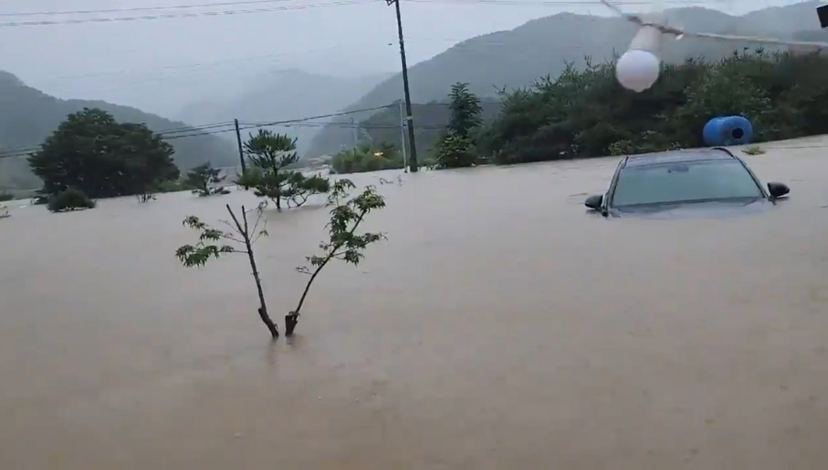 A village is flooded after a dam overflowed due to torrential rain in the central county of Goesan on Saturday (Yonhap)