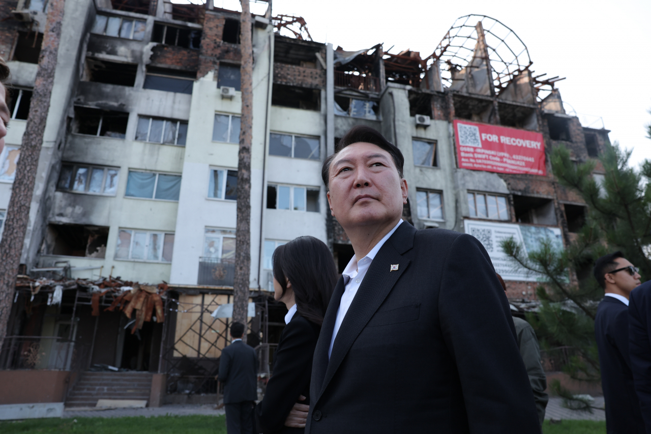 President Yoon Suk Yeol and first lady Kim Keon Hee, who made a surprise visit to Ukraine after an official state visit in Warsaw, the capital of Poland, inspect the bombing site of a private house in Irpin near Kyiv on Saturday. (Yonhap)