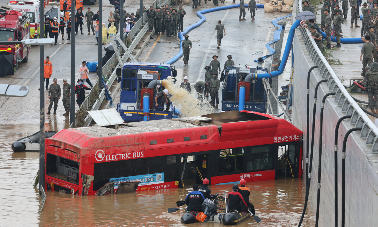 A submerged public bus is salvaged on Sunday from the Gungpyeong 2 underpass in Cheongju, North Chungcheong Province, which was flooded largely due to the nearby Miho River's bank collapse. (Yonhap)