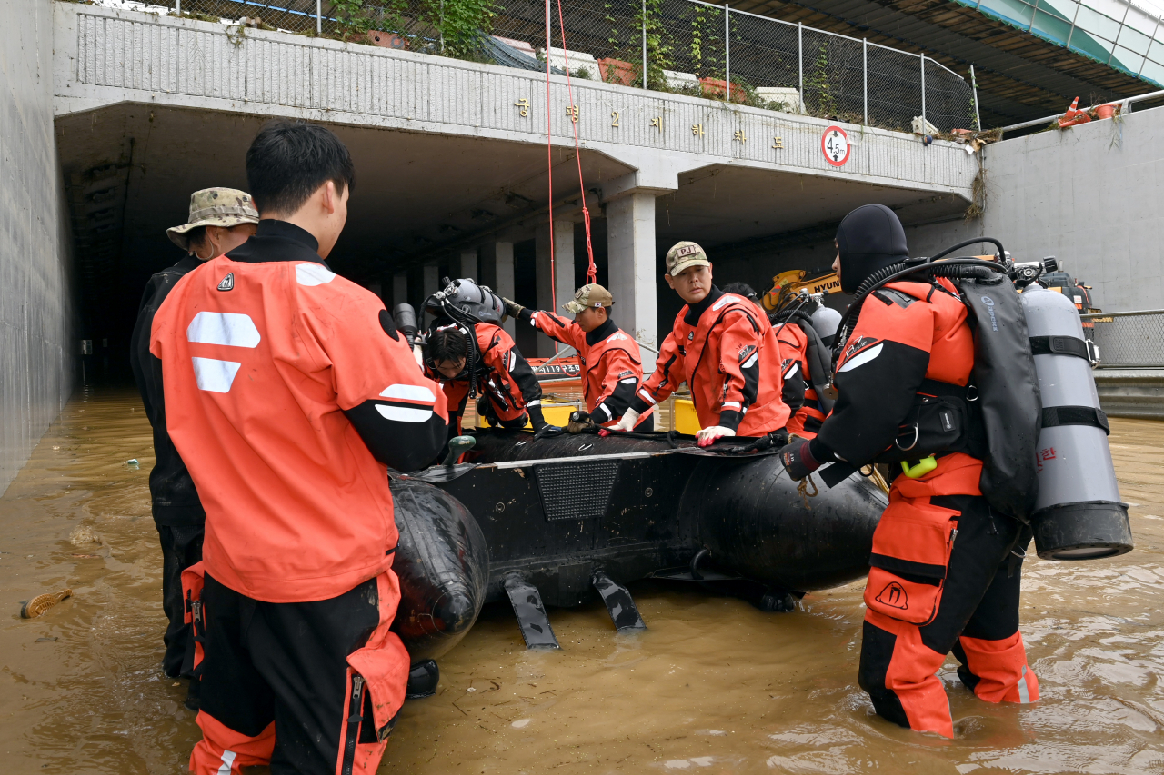 A rescue team from the Air Force enters the Gungpyeong 2 underpass in Cheongju, North Chungcheong Province, which was flooded after the collapse of a nearby river bank, after hours of drainage work. (Yonhap)