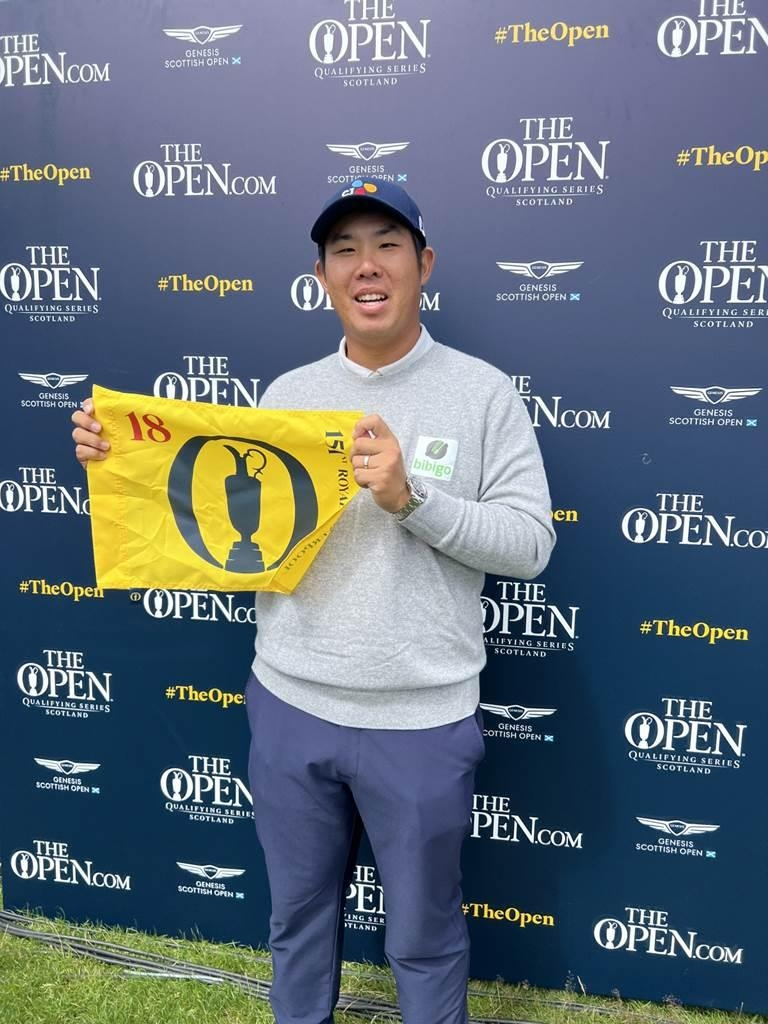 In this photo from Monday, An Byeong-hun of South Korea holds a flag showing the logo for the Open Championship after qualifying for the major tournament by tying for third place at the Genesis Scottish Open in North Berwick, Scotland. ( PGA Tour)