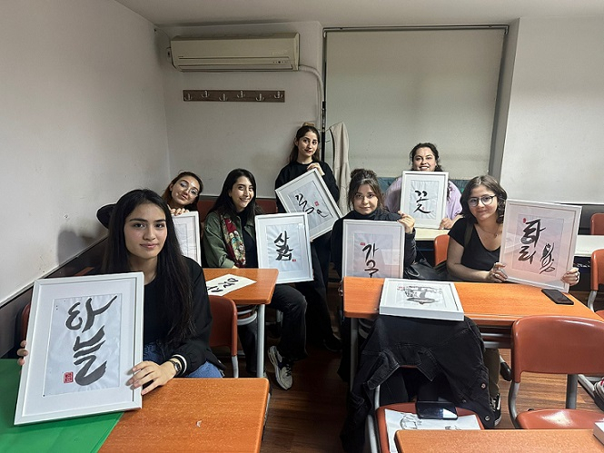 Turkish students pose for a photo showing their calligraphy art pieces. (King Sejong Institute in Istanbul)