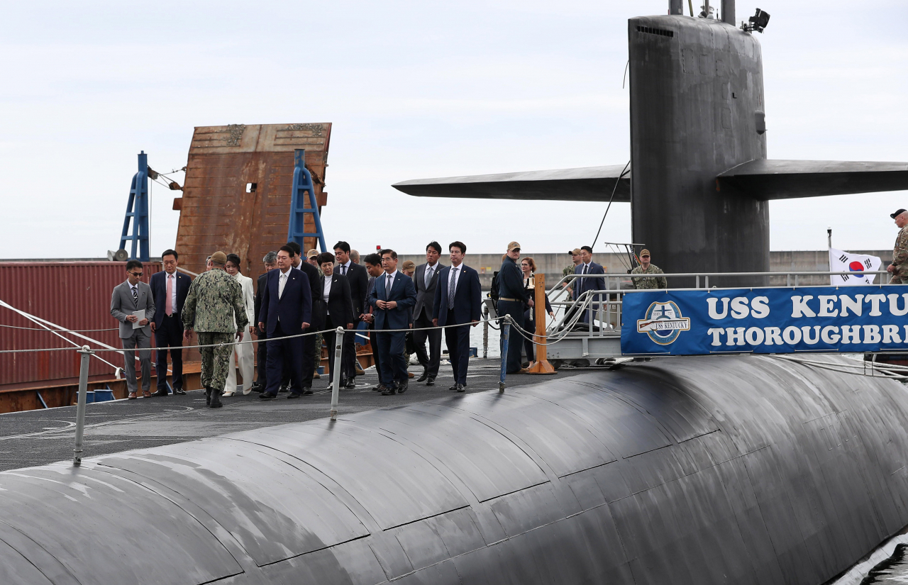 President Yoon Suk Yeol and first lady Kim Keon Hee board the US Navy's Ohio-class ballistic-missile submarine, the USS Kentucky, a day after the ship arrived at a Korean naval base near Busan, marking the first visit of a US nuclear-capable submarine in more than four decades, Tuesday. (Joint Press Corps)