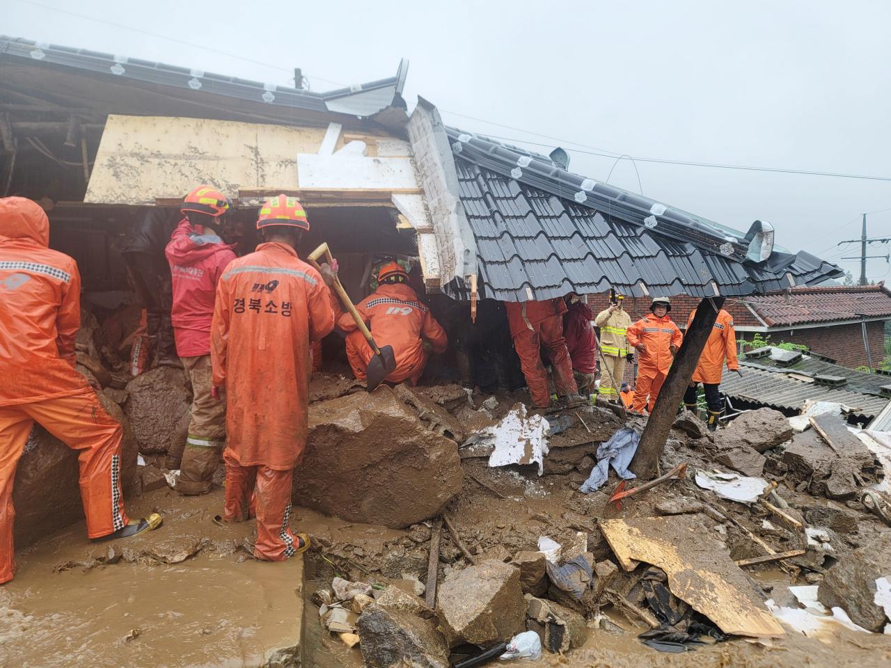 Firefighters carry out a rescue operation after a house was destroyed by landslides in Yeongju, North Gyeongsang Province, Saturday. (Yonhap) Firefighters carry out a rescue operation after a house was destroyed by landslides in Yeongju, North Gyeongsang Province, Saturday. (Yonhap)