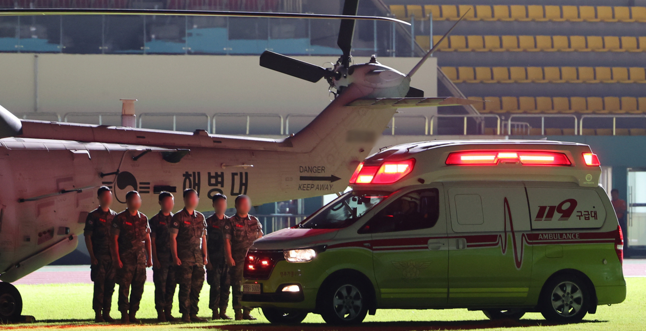 Marines stand next to an ambulance carrying the body of a fallen member at a stadium in the town of Yecheon, North Gyeongsang Province, southeastern South Korea, on Thursday, after he was found dead in the Naeseong Stream in the town the previous day. Rescuers found the soldier who went missing in the stream while participating in a search and rescue operation for people missing after heavy monsoon rains and landslides in the area. (Yonhap)
