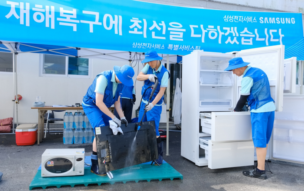 Samsung Electronics service managers inspect home appliances affected by monsoon rains in Gongju, South Chungcheong Province, Wednesday. (Samsung Electronics)