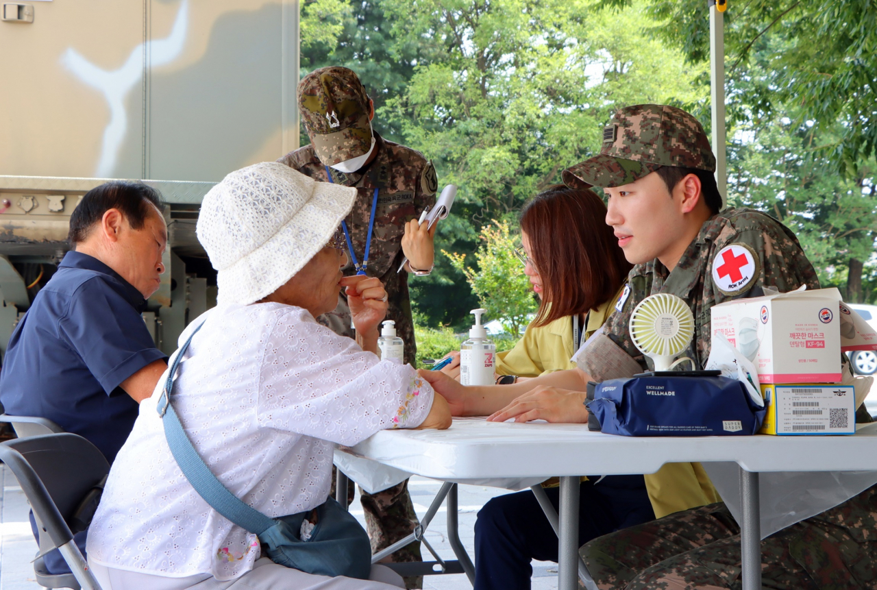 Army medics offer consultation services to residents of flood-stricken Ungjin-dong in Gongju, South Chungcheong Province, Thursday. (Yonhap)