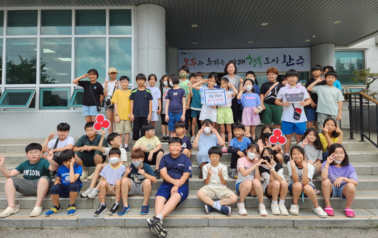 A group of forty students, accompanied by their homeroom teacher, pose for a photo in front of the Iseo-myeon Administrative Welfare Center, in Wanju, North Jeolla Province, Wednesday. (Yonhap)