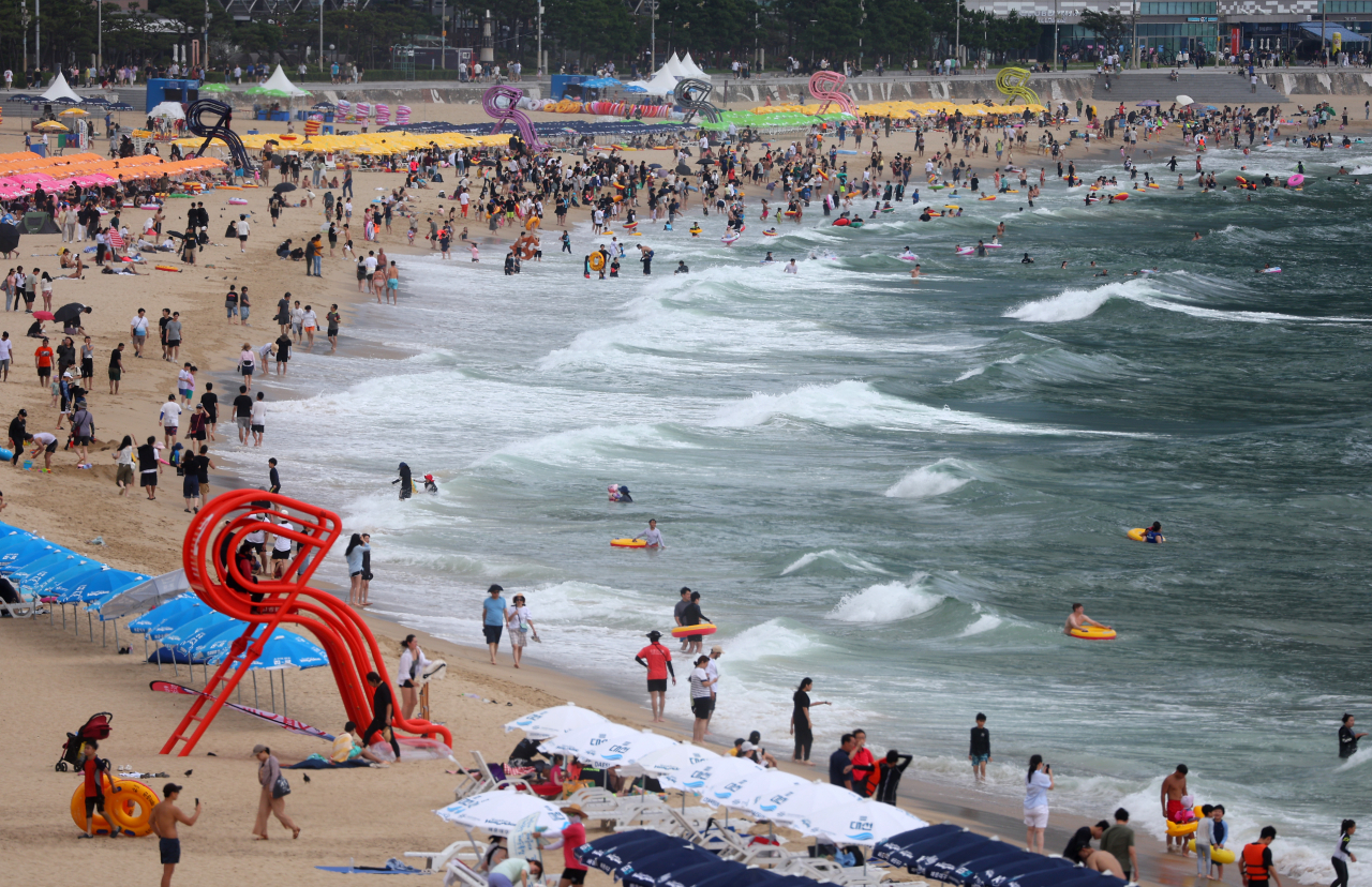 People cool off in the water at Haeundae Beach in Busan, Sunday. (Yonhap)
