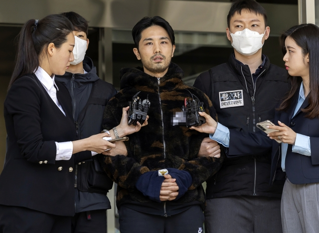 Lee Kyung-woo, center, answers reporters' questions at the Suseo Police Station in Gangnam-gu, Seoul, on April 9 before he is sent over to the prosecution. Lee is a suspect in the kidnapping and murder case of a woman in her 40s in March. (Yonhap)