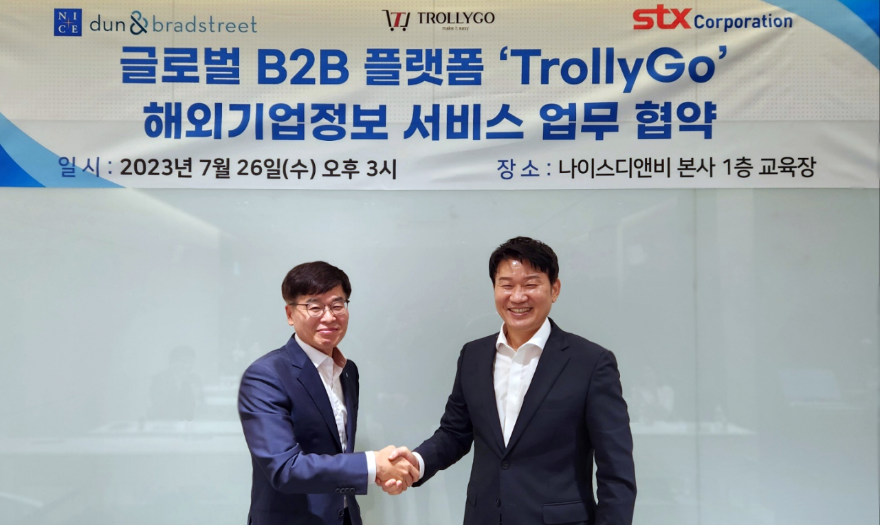 STX CEO Park Sang-jun (right), and NICE D&B CEO Kang Yong-koo pose for a photo after the signing event held at NICE D&B's headquarters in Mapo-gu, Seoul, on July 26. (STX)