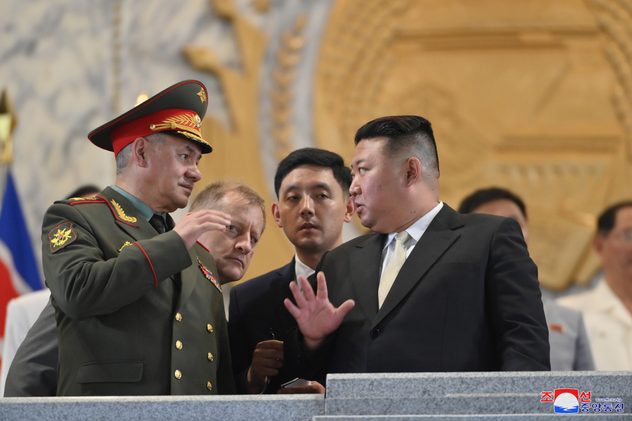 North Korean leader Kim Jong-un (right) talks with Russian Defense Minister Sergei Shoigu as he attends a military parade at Kim Il-sung Square in Pyongyang on Thursday night to mark the 70th anniversary of the signing of the armistice that halted the 1950-53 Korean War, in this photo released the next day by North Korea's official Korean Central News Agency. (Yonhap)