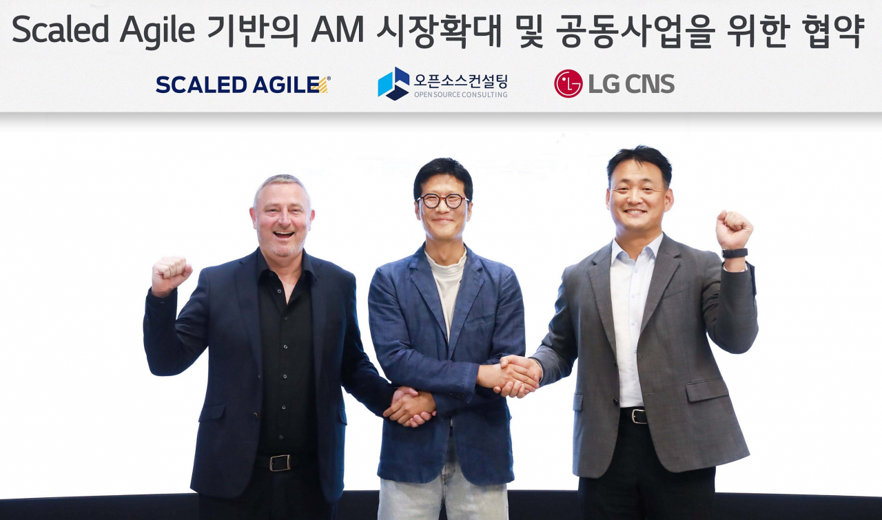 From left: Rob Howard, vice president of Asia Pacific at Scaled Agile, Open Source Consulting CEO Chang Yong-hoon and Kim Tae-hoon, leader of the cloud business division at LG CNS, pose for a photo after signing a memorandum of understanding in Seoul on Friday. (LG CNS)
