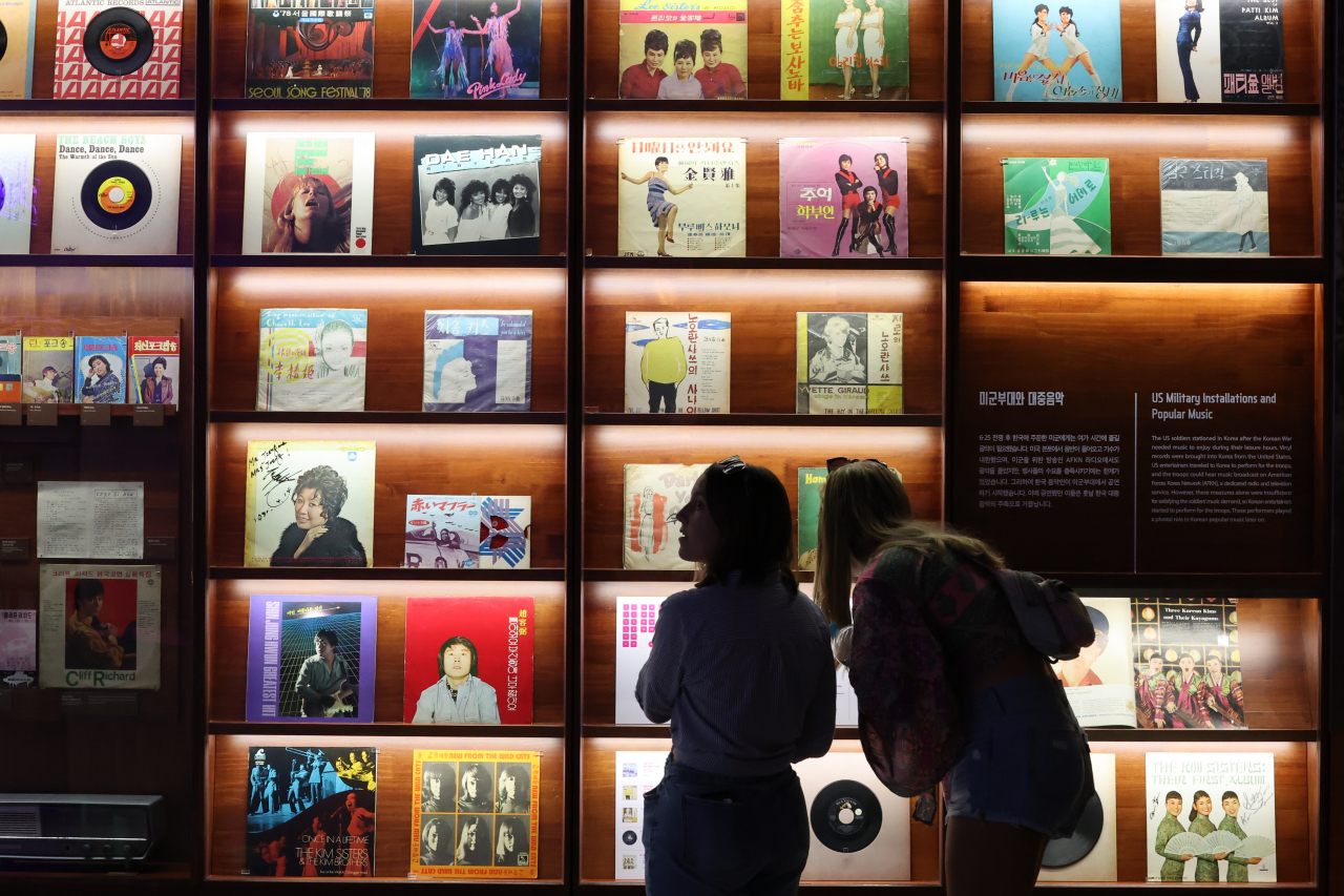 Visitors check out Vinyl records displayed at an exhibition titled “The Pop Culture We Loved and Rise of the Korean Wave
