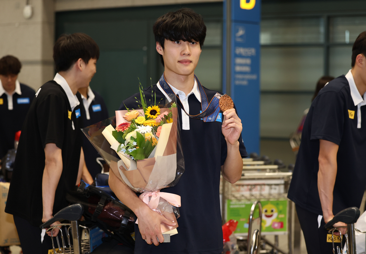 South Korean swimmer Hwang Sun-woo holds up his bronze medal won from the men's 200-meter freestyle at the World Aquatics Championships in Fukuoka, Japan, upon arriving at Incheon International Airport, west of Seoul, on July 31, 2023. (Yonhap)