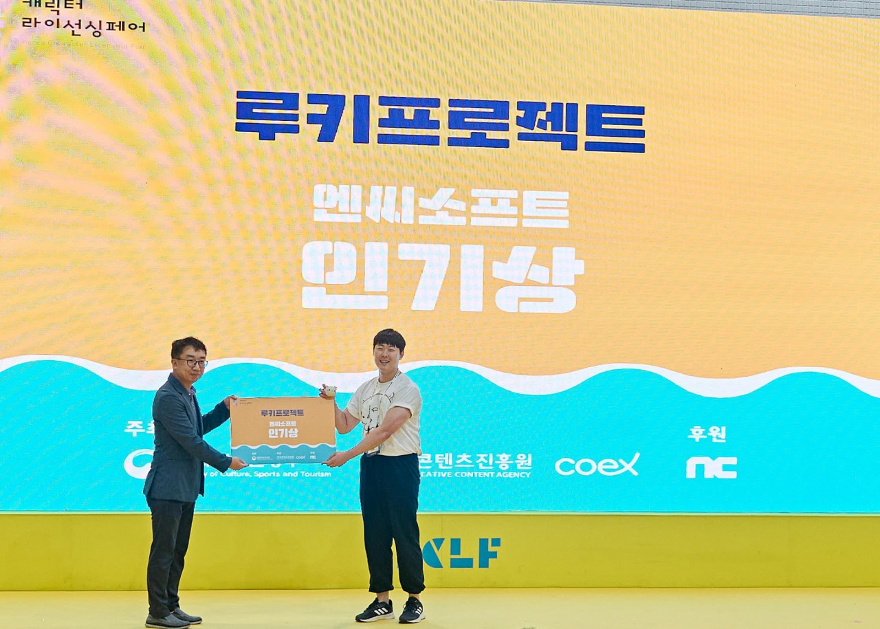 An artist receives a popularity award on July 16 for the character he invented at the Korea Character Licensing Fair 2023, held at Coex, Seoul, July 13-16. (NCSoft)