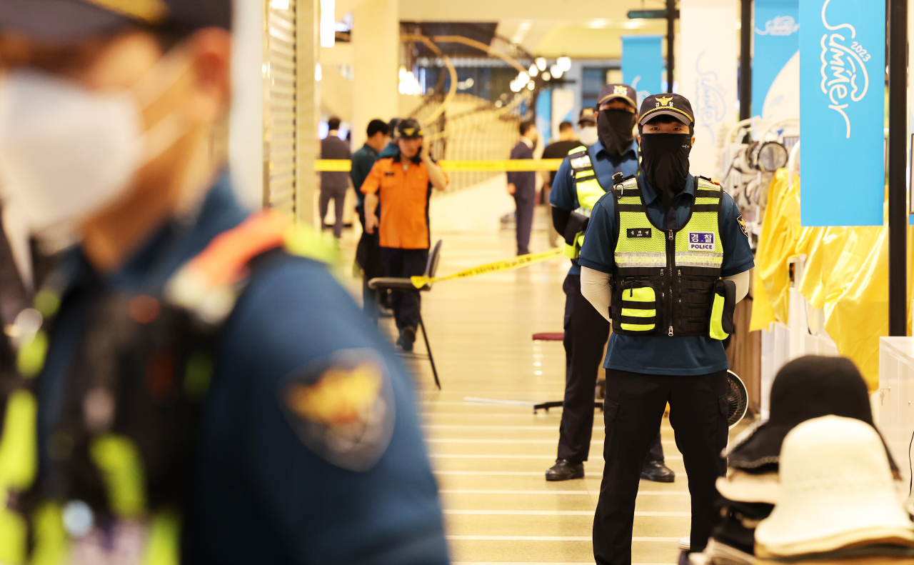 Police stand guard at a department store in Bundang, Gyeonggi Province where a stabbing rampage occurred, Thursday.(Yonhap)