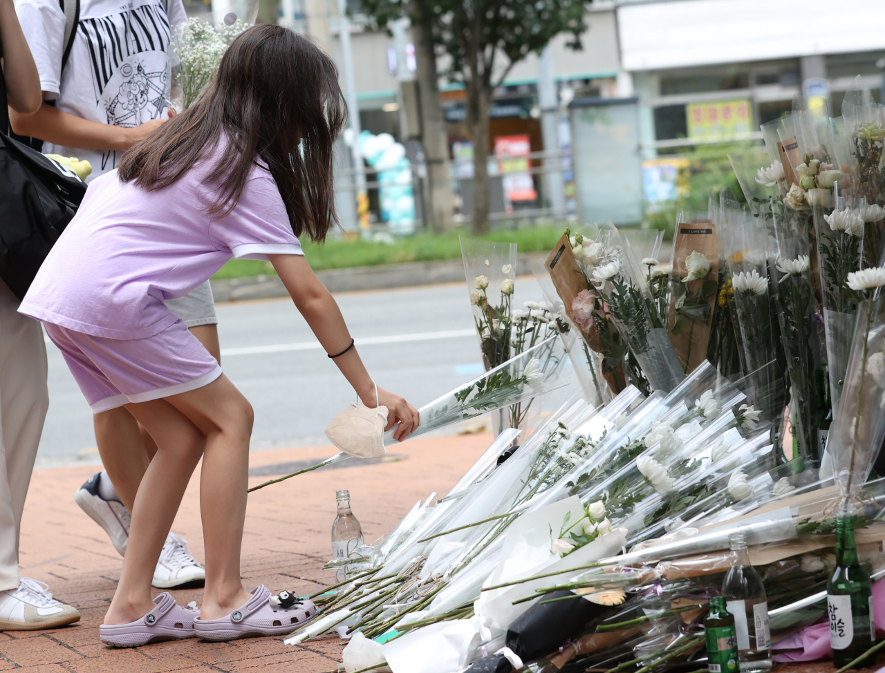A child pays tribute to the victim of Sillim Station, at a makeshift altar in Sillim-dong, southern Seoul in this July 25 photo. (Yonhap)