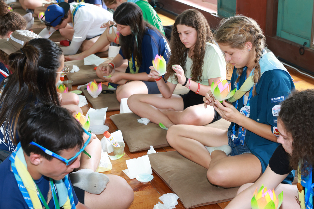 Scout members who participated in the 2023 World Scout Jamboree make lotus lanterns at the Buddhist templ Geumsansa in North Jeolla Province. (Yonhap)