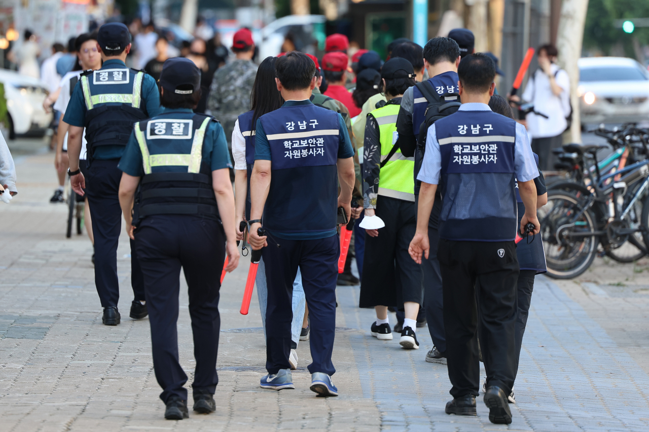 Police officers and security volunteers patrol around Hanti Station in southern Seoul on Friday, following an online threat by an unidentified individual to commit a similar crime as the stabbing rampage that occurred the previous day in the Bundang district, located south of Seoul. (Yonhap)