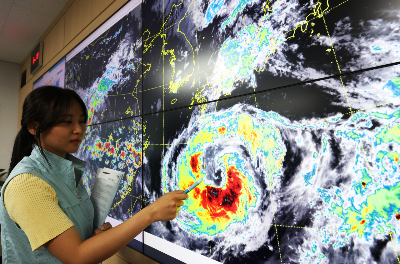 An official at the Korea Meteorological Administration points out from a screen which shows projected path of typhoon Khanun on Monday. (Yonhap)