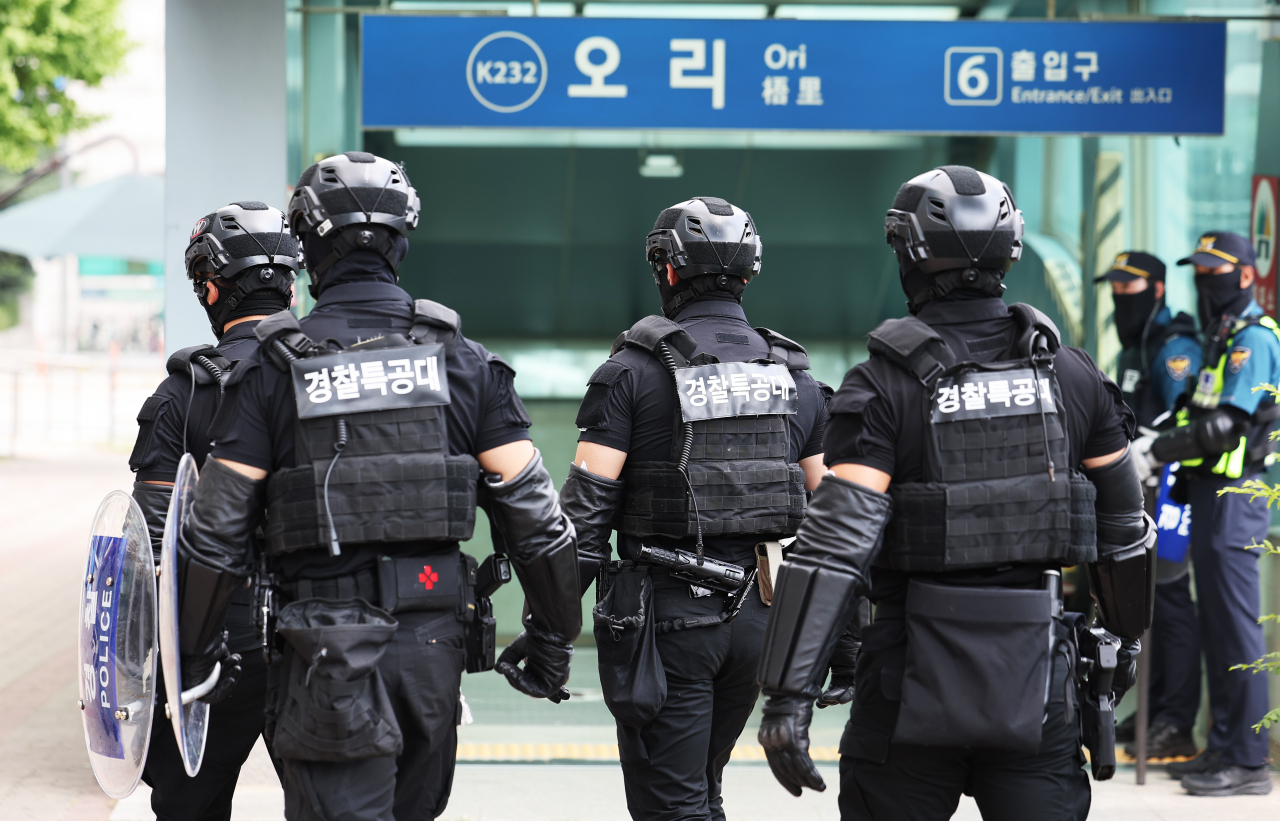 Police officers in riot gear patrol around Ori Station in southern Seoul following an online threat, Friday (Yonhap)