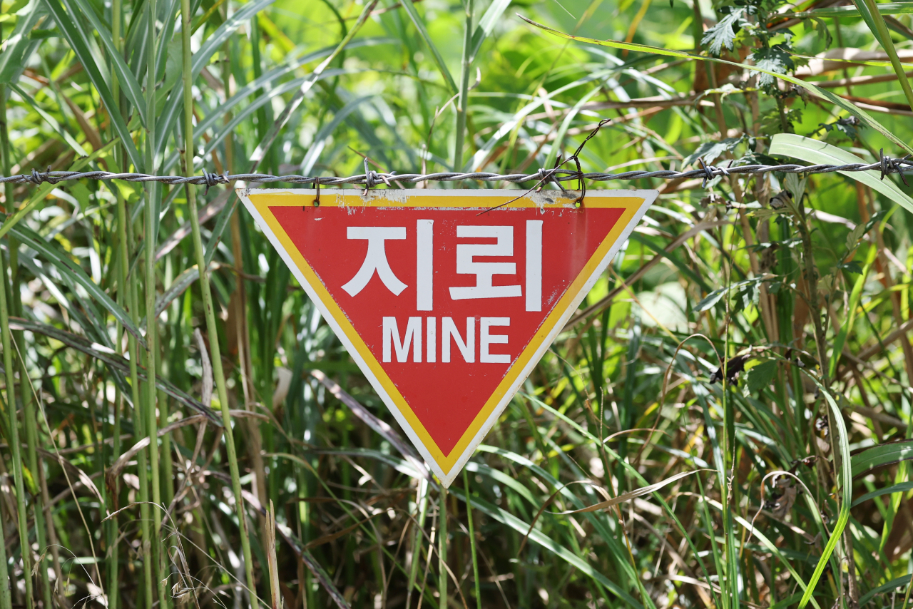 A landmine warning hangs on a barbed wire preventing access to the Demilitarized Zone (DMZ) in Goseong County, Gangwon Province, July 26. This week marks the 70th anniversary of the signing of the Korean Armistice Agreement which temporarily stopped the Korean War on July 27, 1953. Photo © Hyungwon Kang