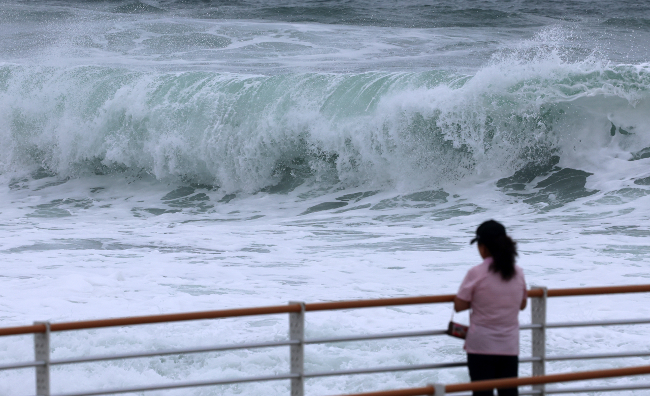 A woman looks at high waves at a beach in Gangneung, 163 kilometers east of Seoul, on Aug. 8, 2023, as Typhoon Khanun is forecast to hit the country's southeastern region two days later. (Yonhap)