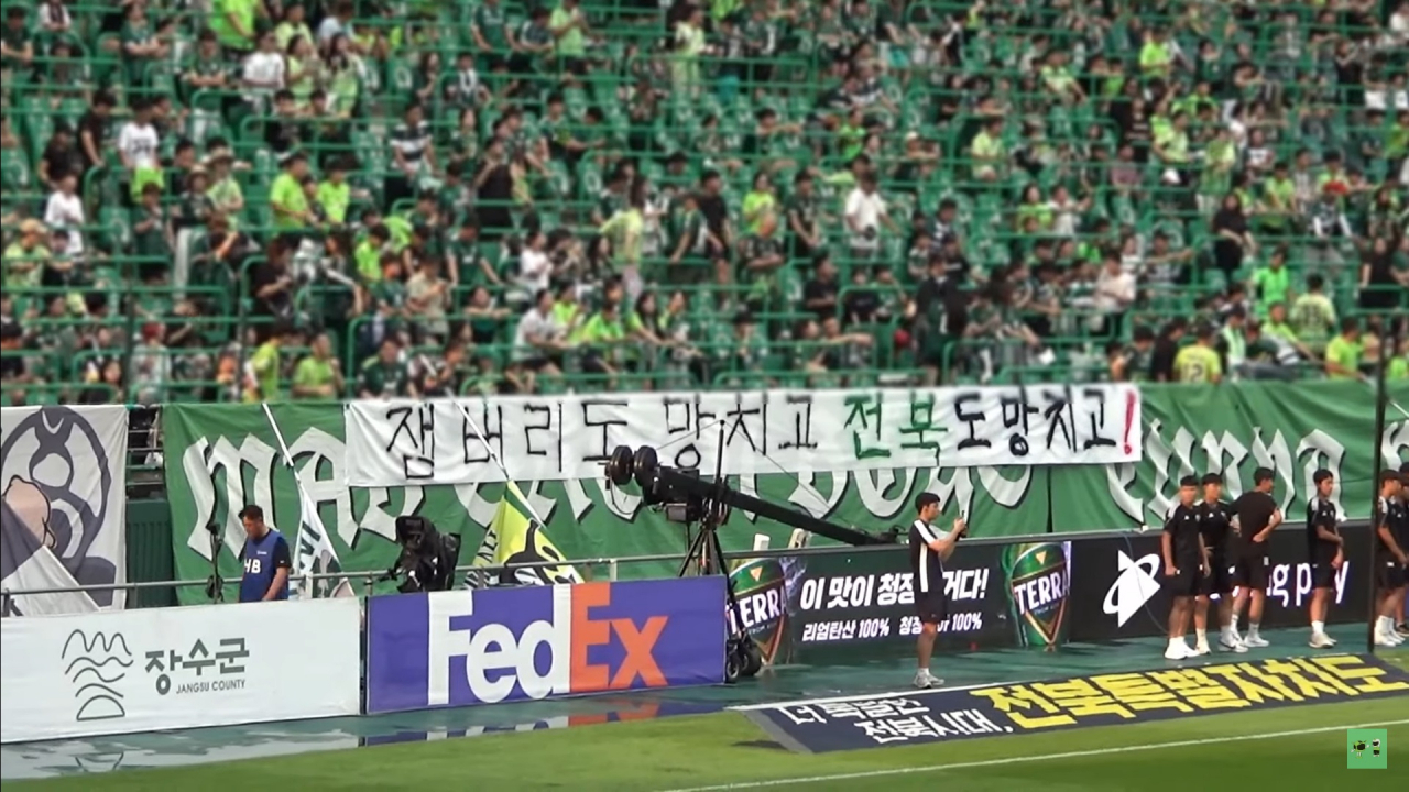 A screenshot image shows Jeonbuk Hyundai Motors FC fans with a sign that reads 