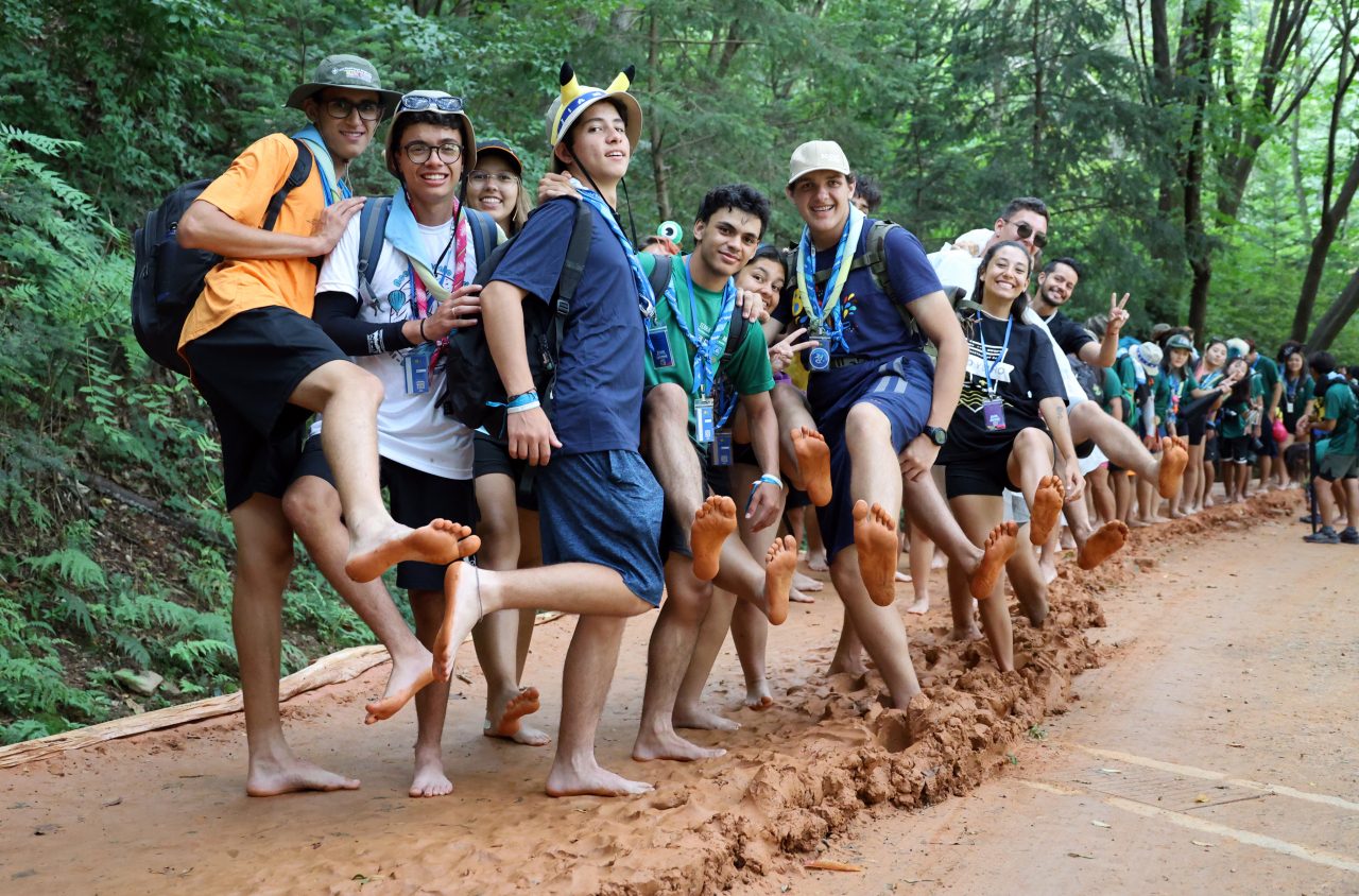 Brazilian Scouts, who are staying in Daejeon after leaving their campsite in the Saemangeum reclamation area in Buan, North Jeolla Province the previous day due to the approaching Typhoon Khanun, participate in a barefoot walking experience on the Jangdong Gyejok Mountain Yellow Mud Trail in Daejeon on Wednesday. (Yonhap) . (Source: Yonhap News)