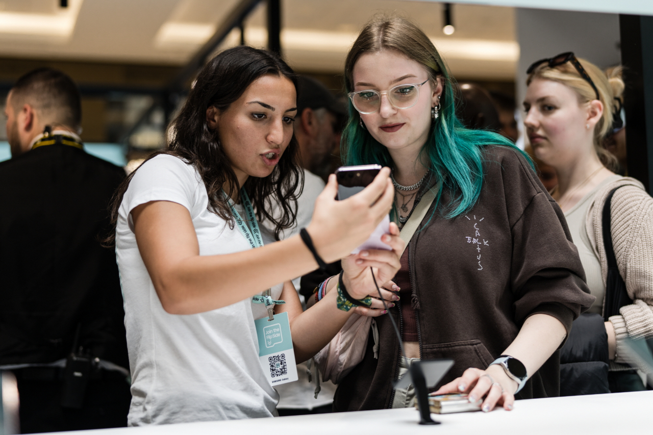 Customers try out Samsung Electronics' latest Galaxy Z Flip5 smartphone at Samsung Experience Store in Berlin, Germany, Wednesday. (Samsung Electronics)