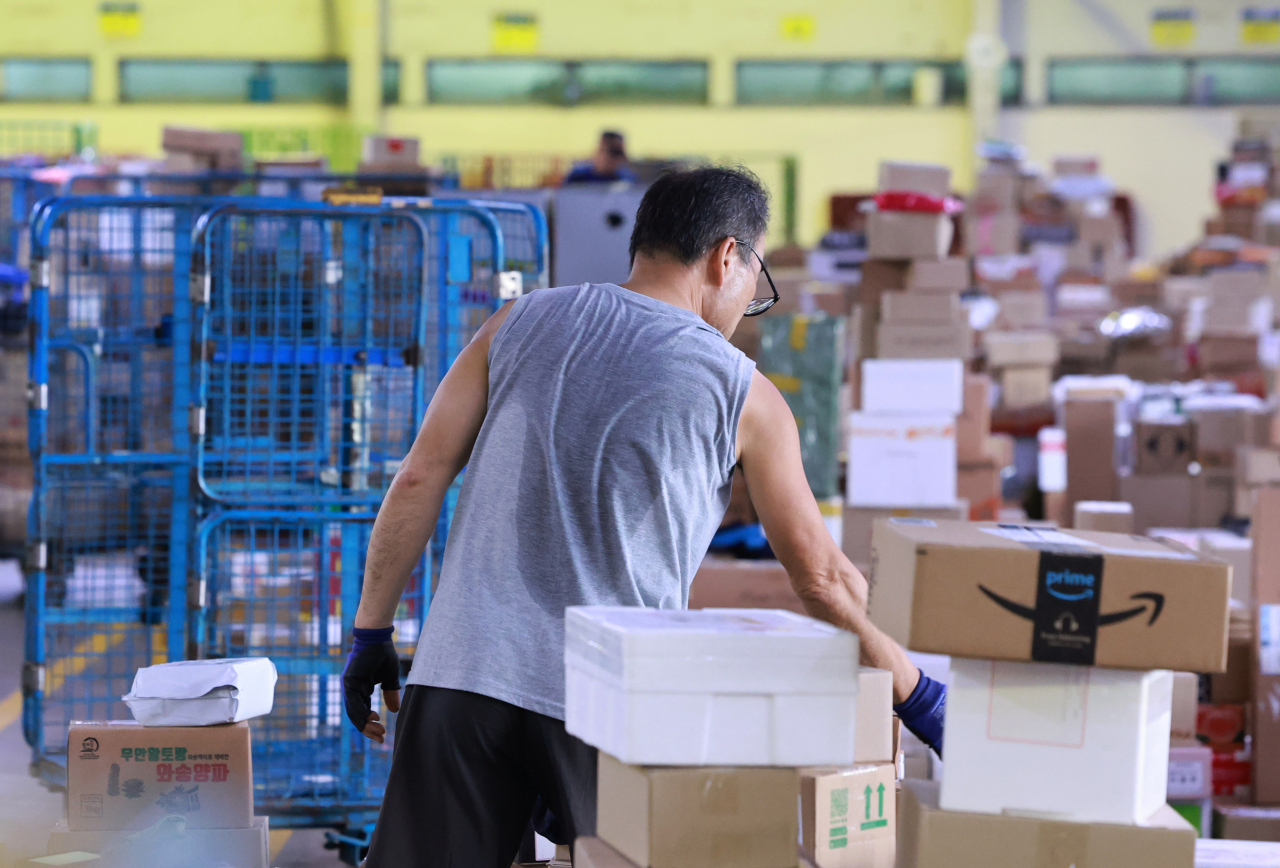 An employee at DongSeoul Mail Center in Gwangjin-gu, Seoul is organizing and sorting through parcels on Aug. 1. (Yonhap)