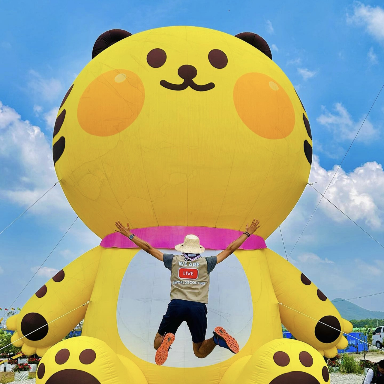 Yassine Gandouz, an International Service Team volunteer from Tunisia, jumps for a photo in front of the 2023 World Scout Jamboree mascot, Saebeomi. (Courtesy of Yassine Gandouz)