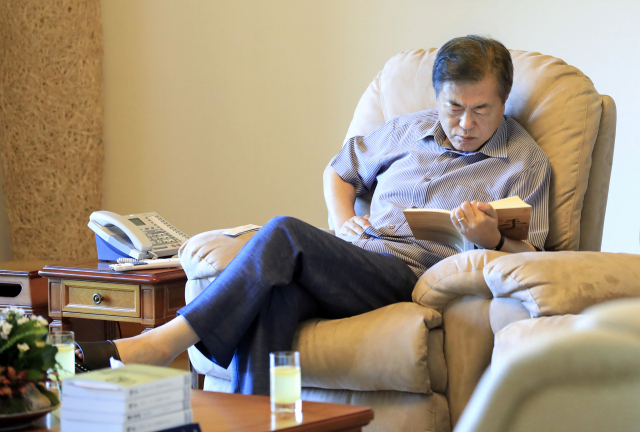 Former President Moon Jae-in is seen reading a book at his vacation home in South Chungcheong Province on Aug. 2, 2018. (The presidential office during Moon's tenure)