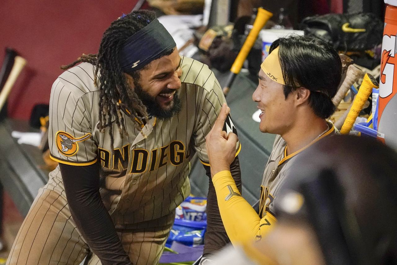 San Diego Padres' Fernando Tatis Jr. (left) has a laugh with Kim Ha-Seong (right) in the dugout after they scored against the Arizona Diamondbacks during the ninth inning of a baseball game Friday in Phoenix. (AP-Yonha)